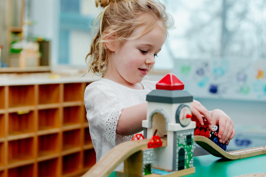 Young girl playing with toy trains