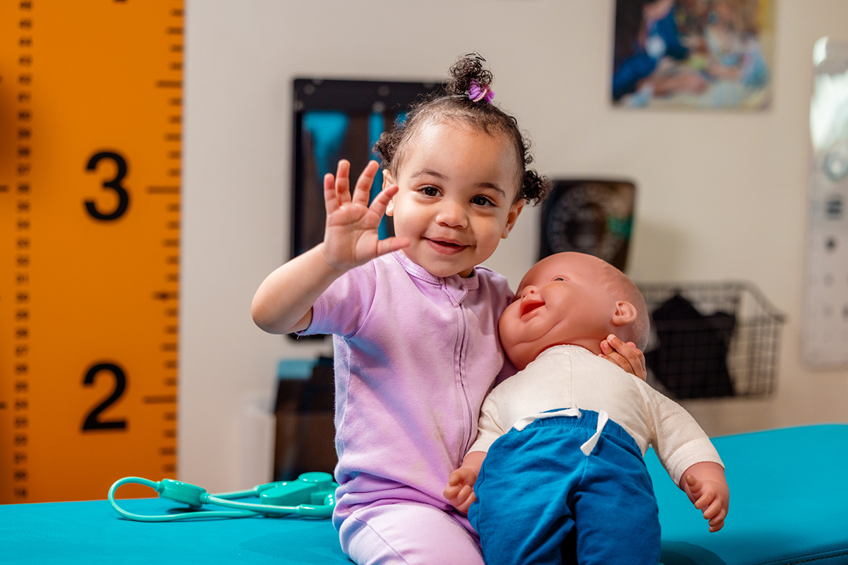 Toddler holding toy baby