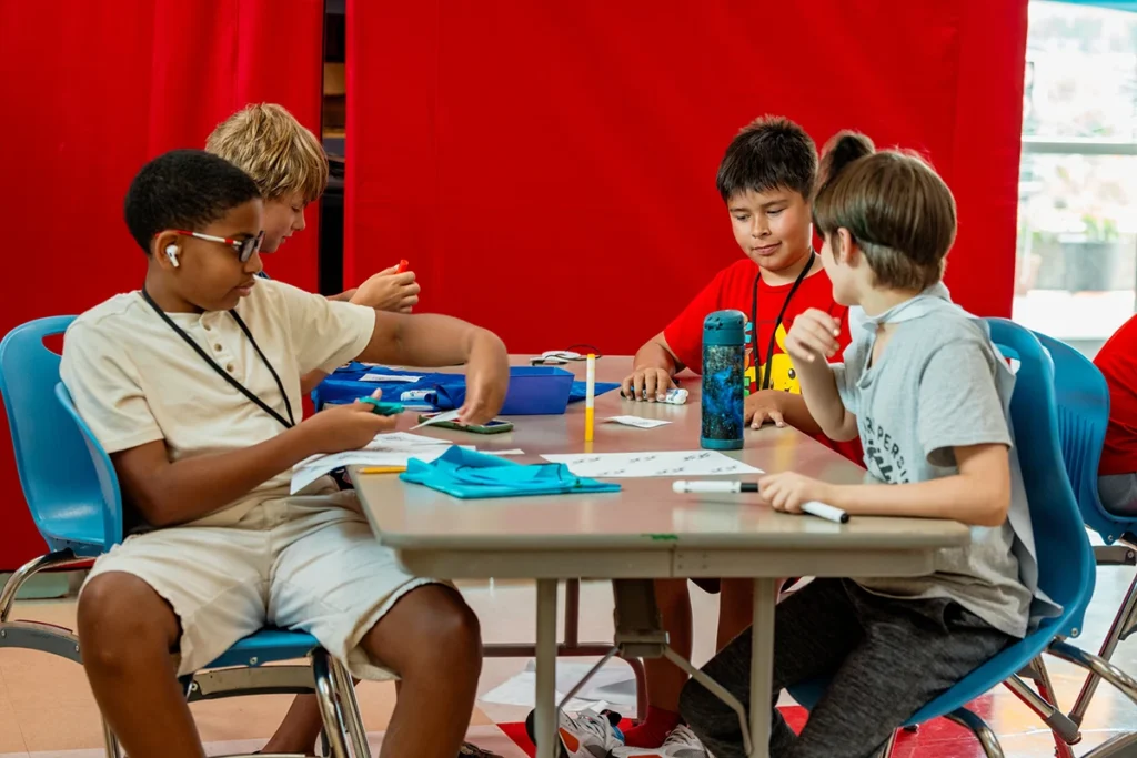 Four boys working on crafts at a table