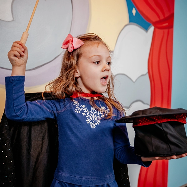 girl dressed as magician doing a magic trick