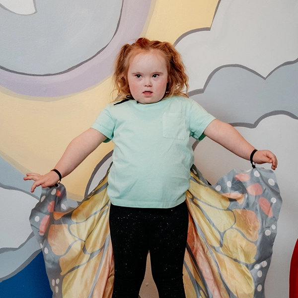 Young girl showing off butterfly costume