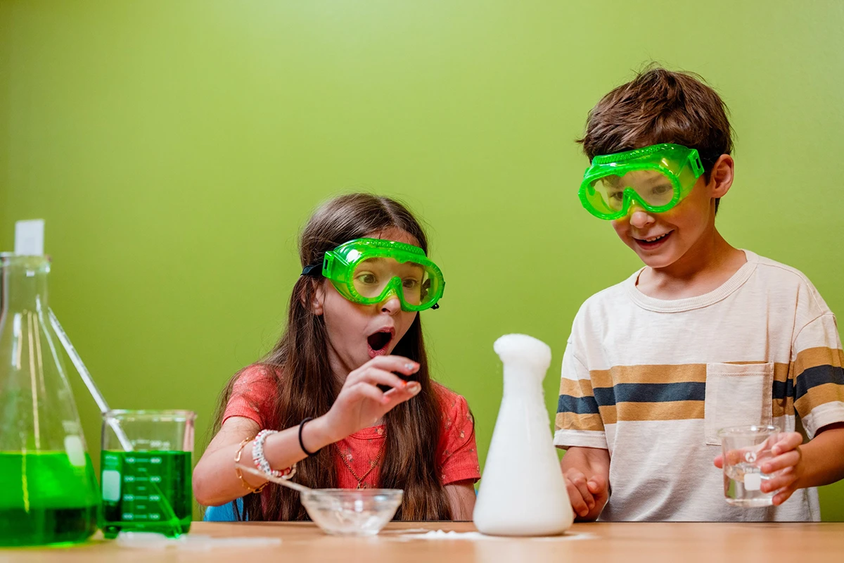 young girl and boy conducting science experiment with beakers