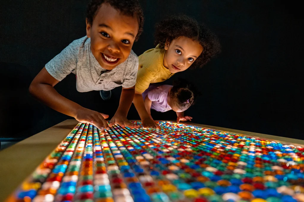 3 children playing with light board