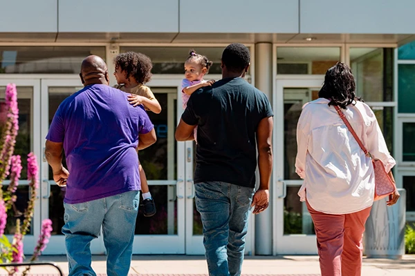 the backs of a family walking into the museum