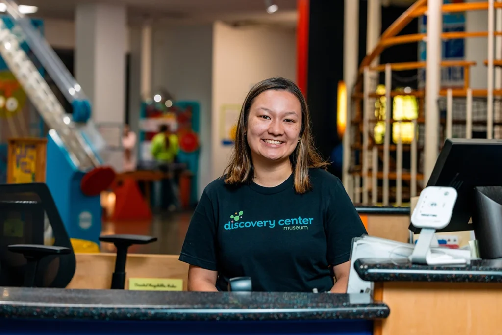 staff member smiles while working at front desk