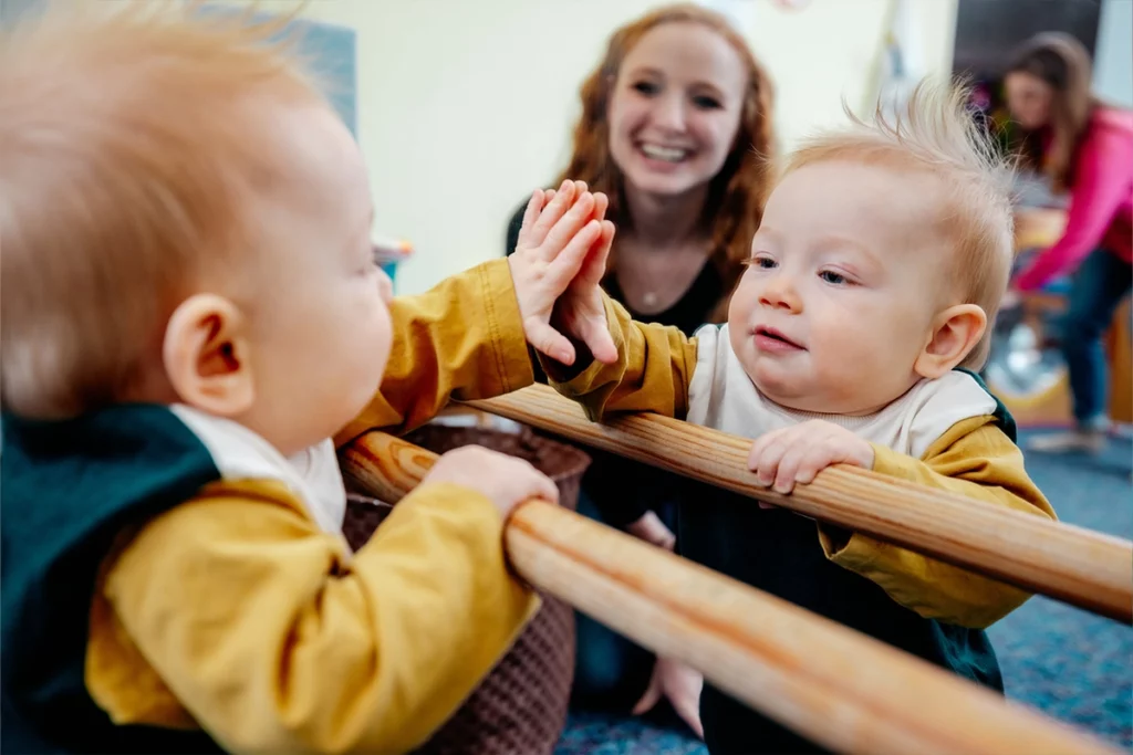 toddler plays with his reflection