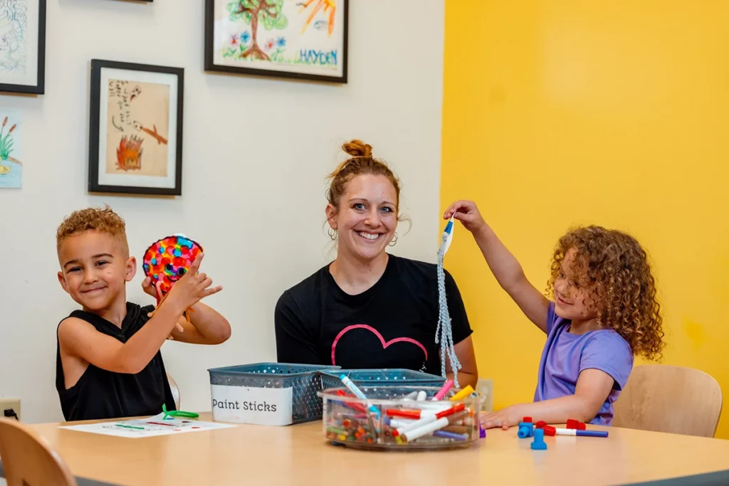 Family sits at craft table making art